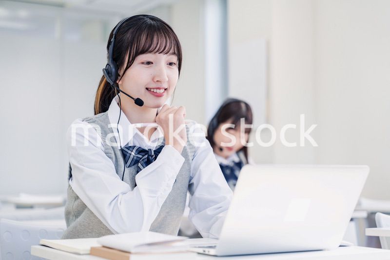 教室でノートパソコンを使う女子高生