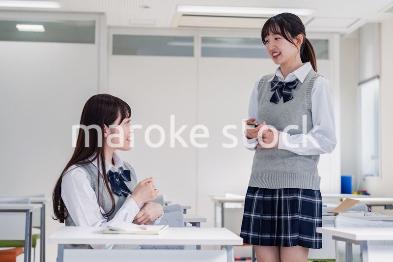 教室で休み時間に話す女子高生