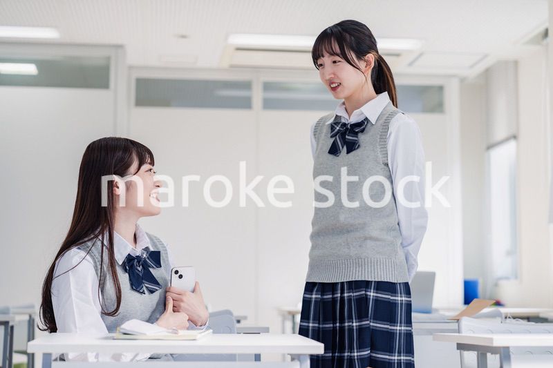 教室で休み時間に話す女子高生