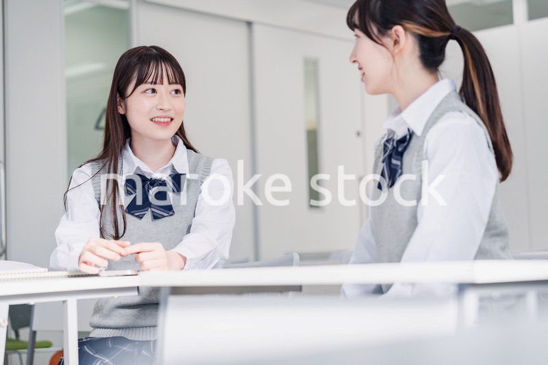 教室で休み時間に話す女子高生