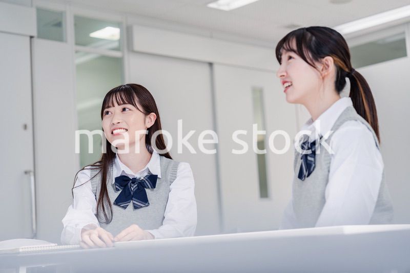 教室で休み時間に話す女子高生