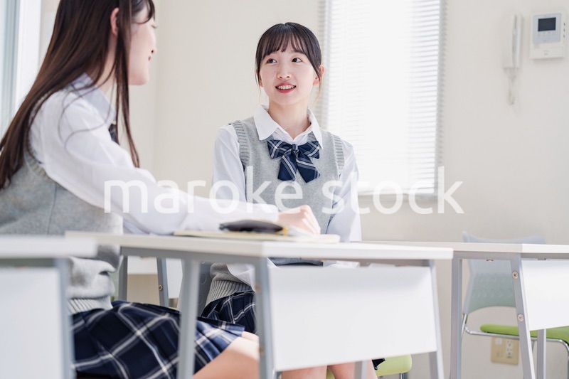 教室で休み時間に話す女子高生