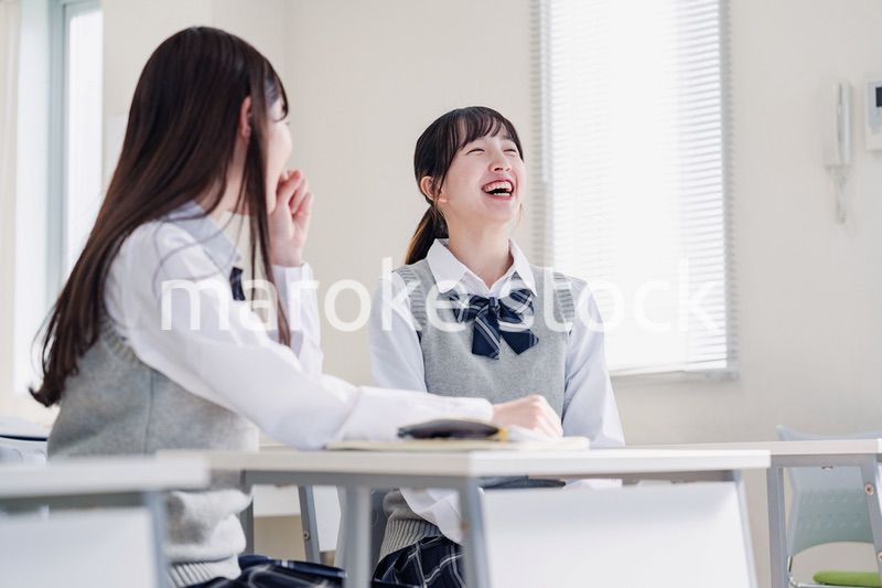 教室で休み時間に話す女子高生