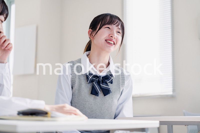 教室で休み時間に話す女子高生