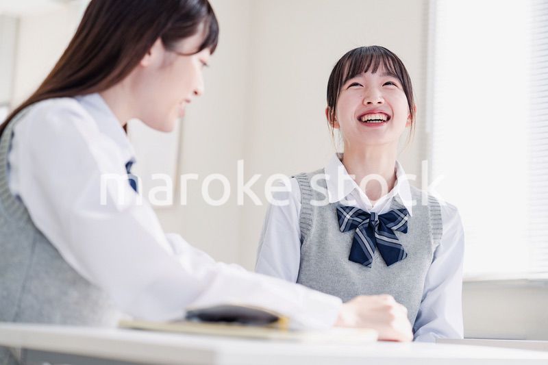 教室で休み時間に話す女子高生