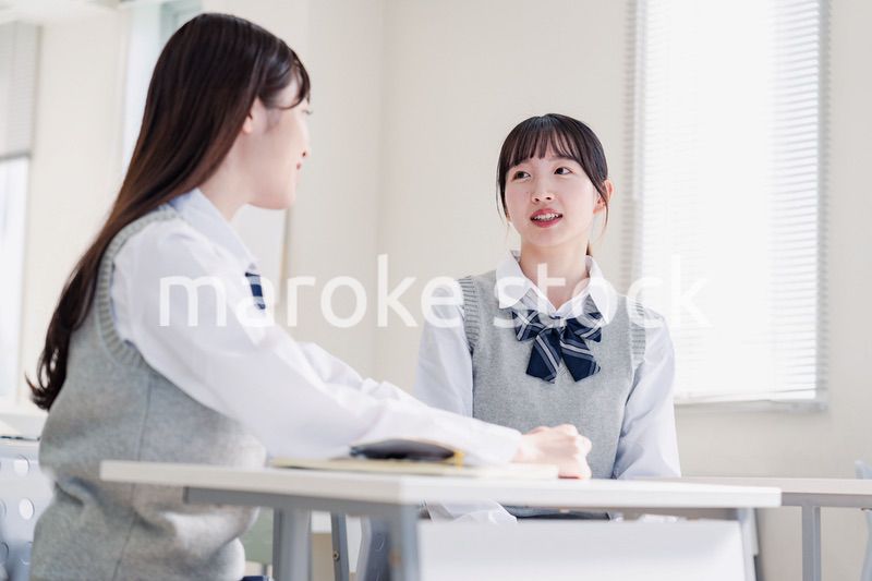教室で休み時間に話す女子高生