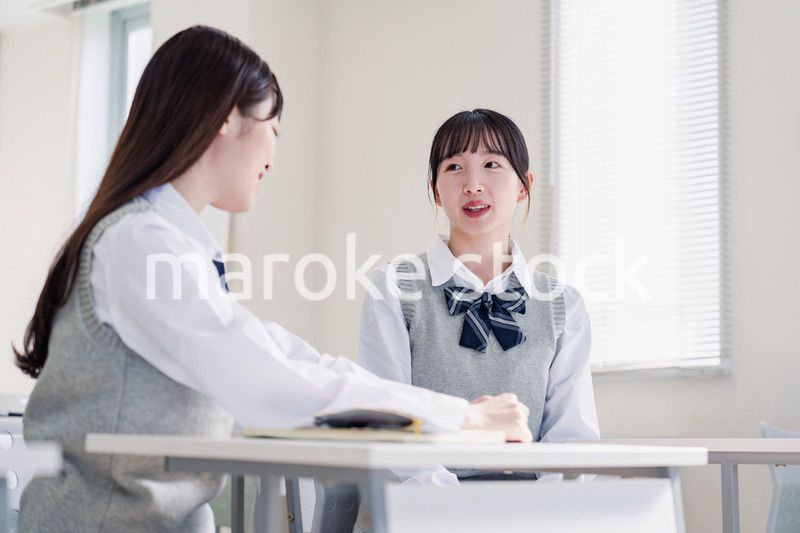 教室で休み時間に話す女子高生
