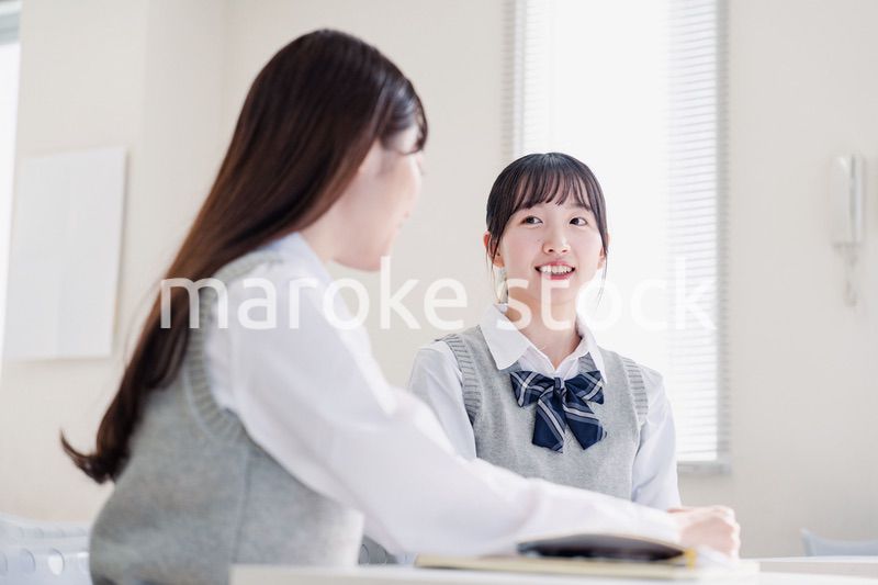 教室で休み時間に話す女子高生