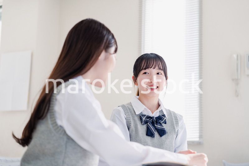 教室で休み時間に話す女子高生