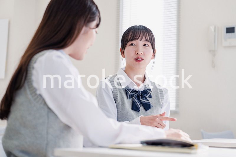 教室で休み時間に話す女子高生