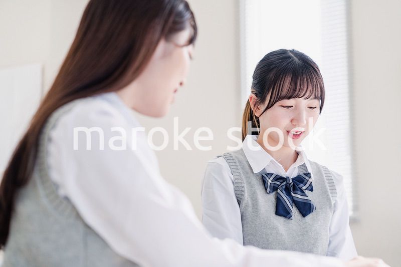 教室で休み時間に話す女子高生