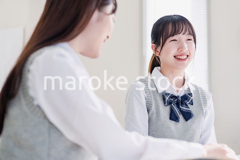教室で休み時間に話す女子高生