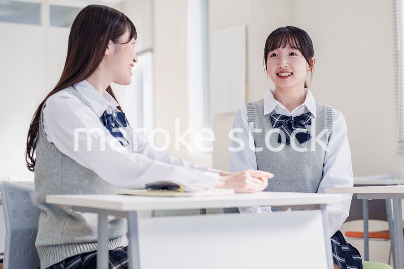 教室で休み時間に話す女子高生
