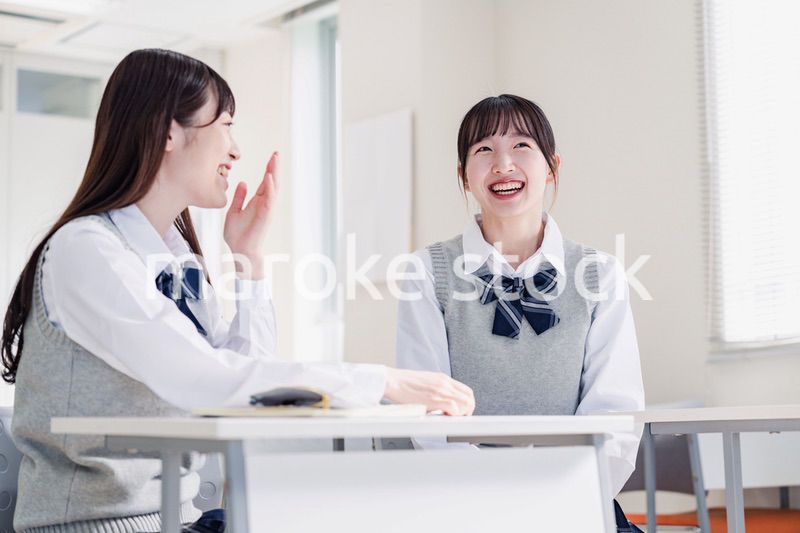 教室で休み時間に話す女子高生