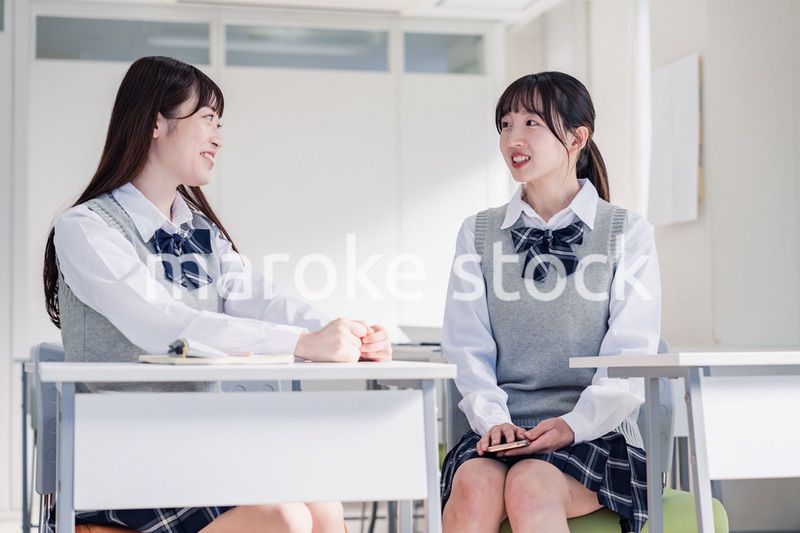 教室で休み時間に話す女子高生