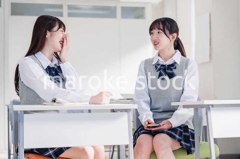 教室で休み時間に話す女子高生