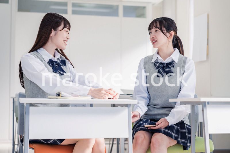 教室で休み時間に話す女子高生