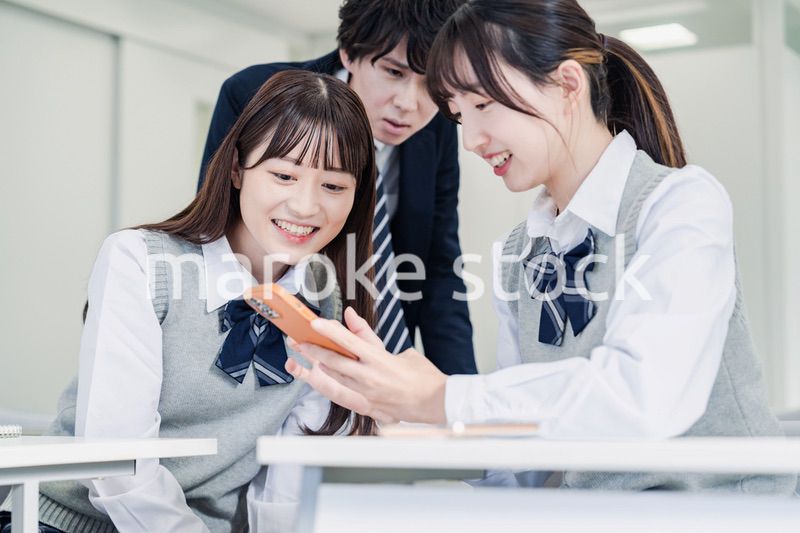 教室でSNSをみんなで見る高校生