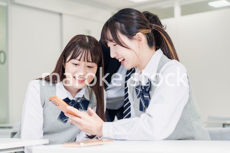 教室でSNSをみんなで見る高校生