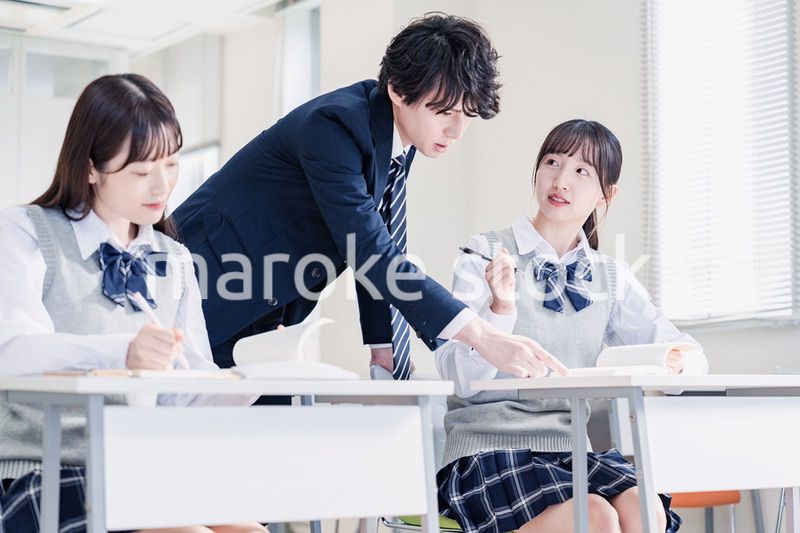 教室で先生に質問をする高校生