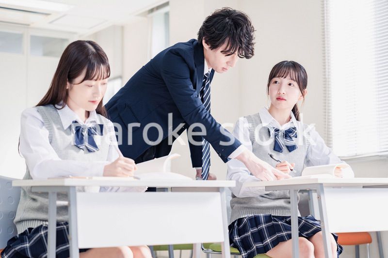 教室で先生に質問をする高校生