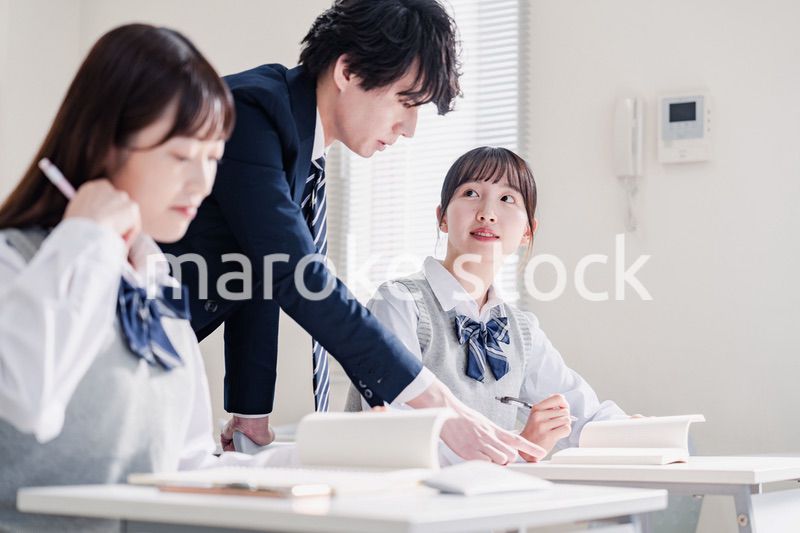 教室で先生に質問をする高校生