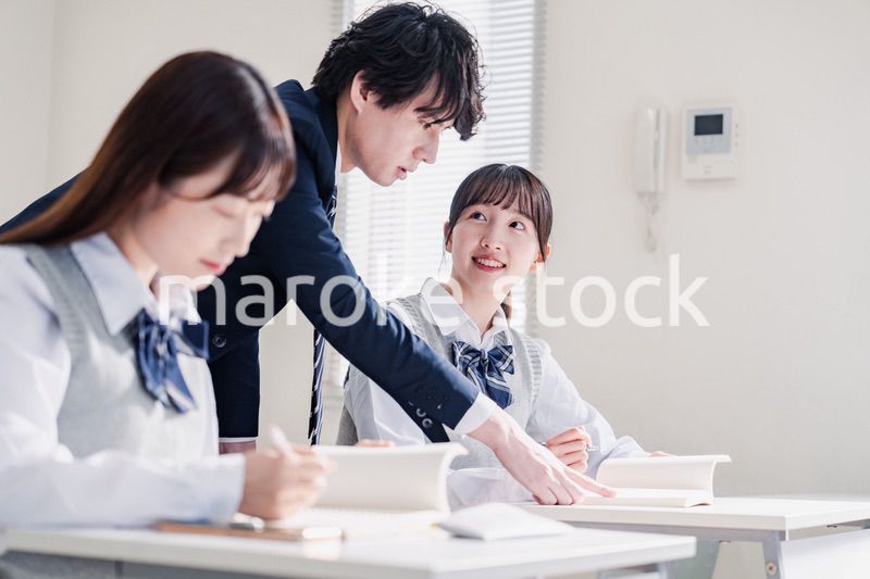 教室で先生に質問をする高校生