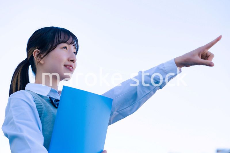 制服で上を指差す女子高生