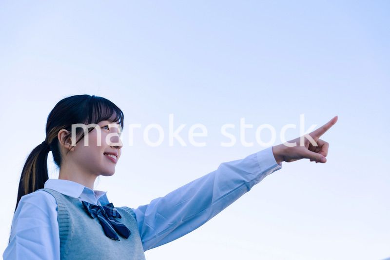 制服で上を指差す女子高生