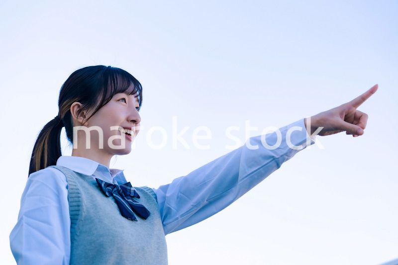 制服で上を指差す女子高生