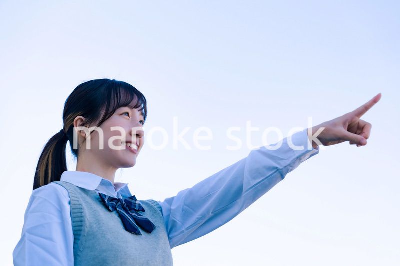 制服で上を指差す女子高生