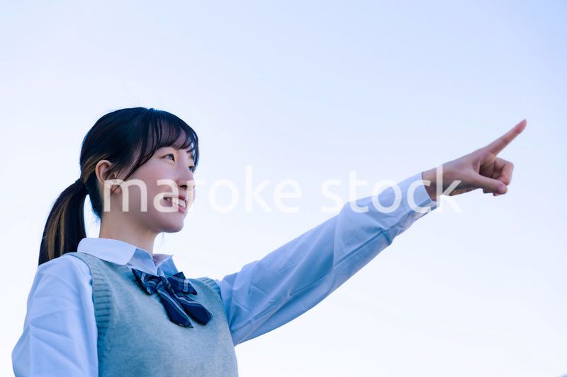 制服で上を指差す女子高生