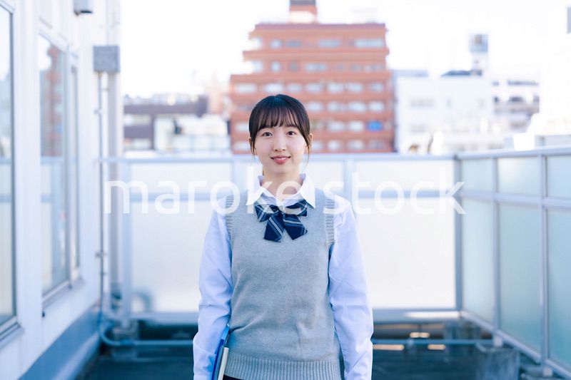 学校の屋上を歩く女子高生