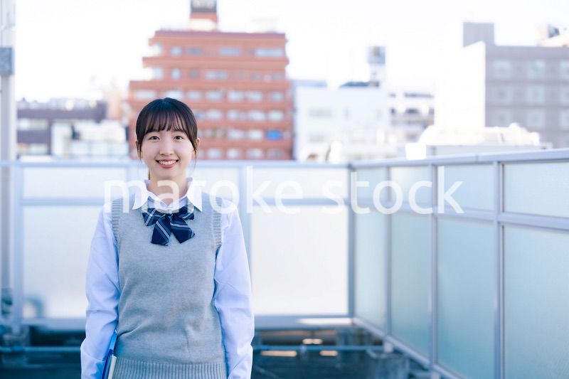 学校の屋上を歩く女子高生