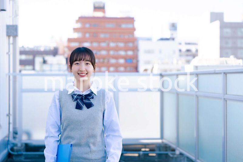 学校の屋上を歩く女子高生