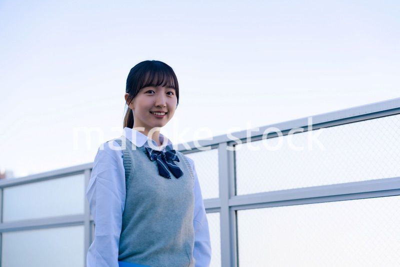 学校の屋上を歩く女子高生