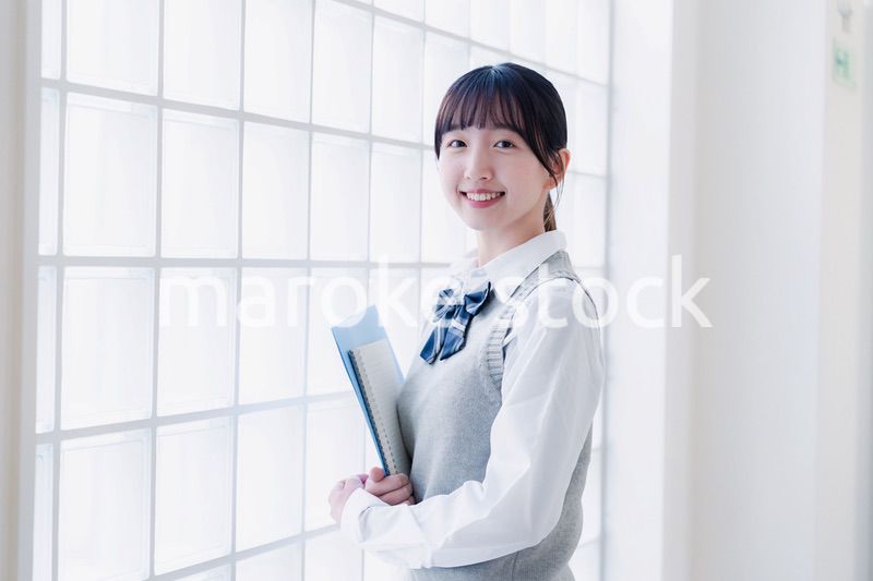 教材を持って校内を歩く女子高生