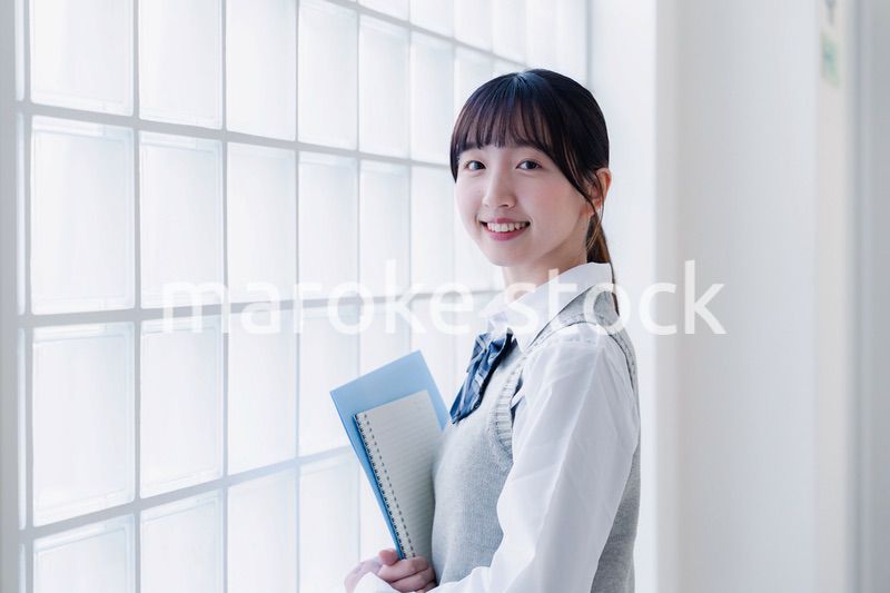 教材を持って校内を歩く女子高生