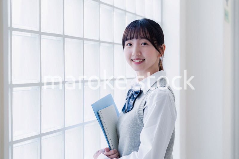 教材を持って校内を歩く女子高生