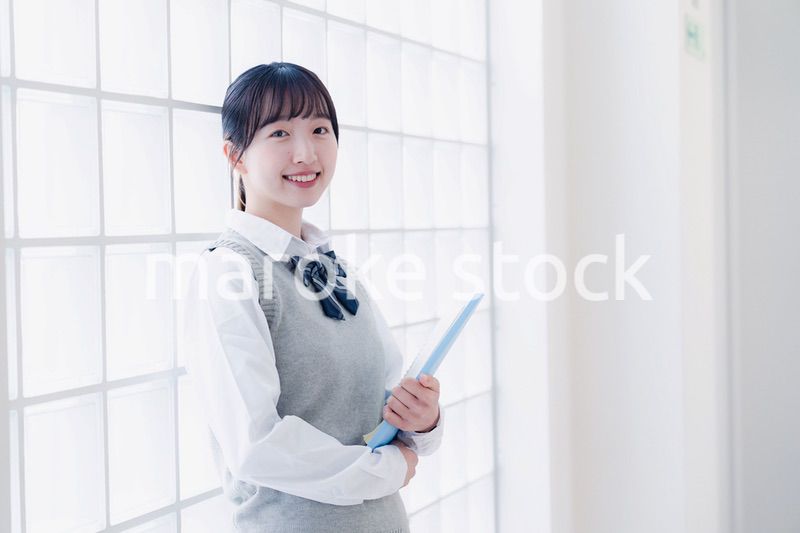 教材を持って校内を歩く女子高生