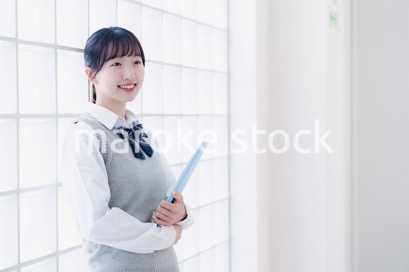 教材を持って校内を歩く女子高生