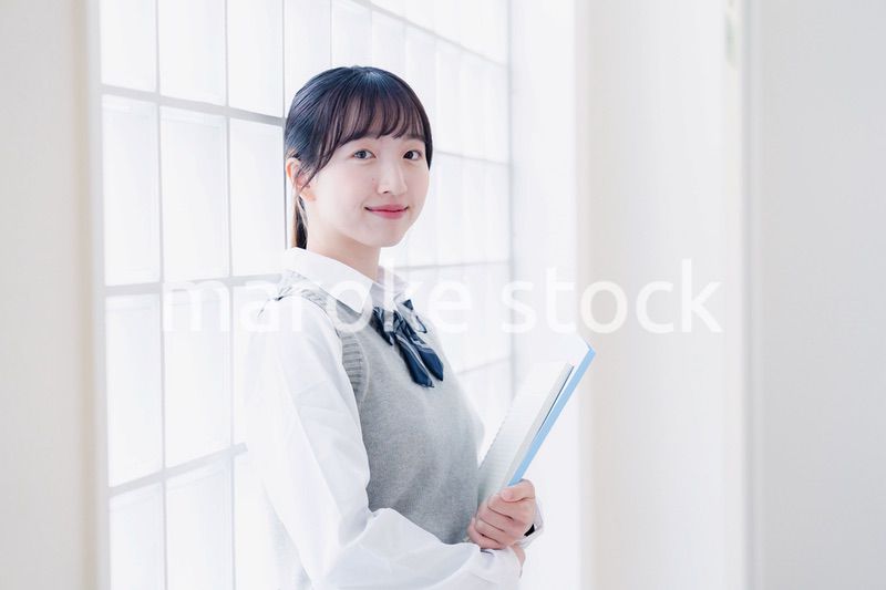 教材を持って校内を歩く女子高生