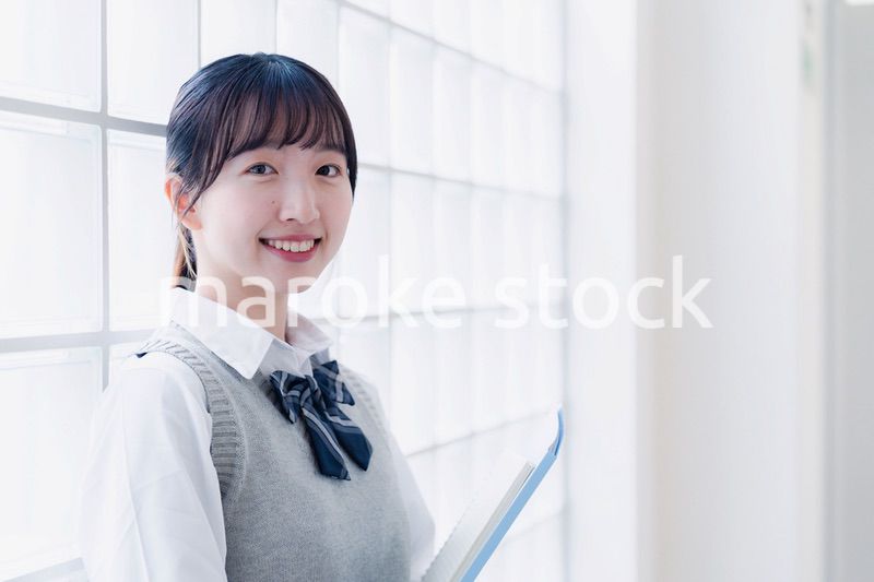 教材を持って校内を歩く女子高生