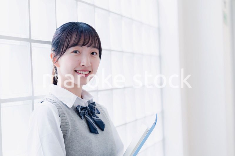 教材を持って校内を歩く女子高生