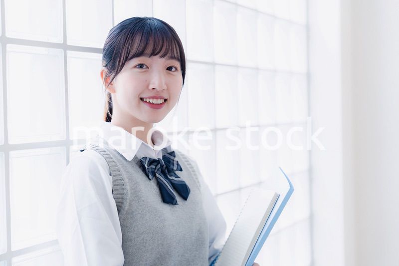 教材を持って校内を歩く女子高生