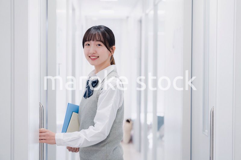 教材を持って校内を歩く女子高生