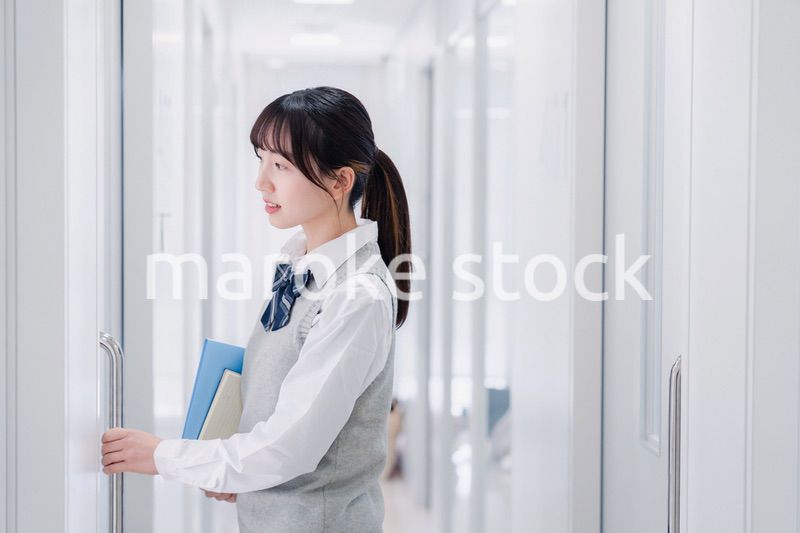 教材を持って校内を歩く女子高生