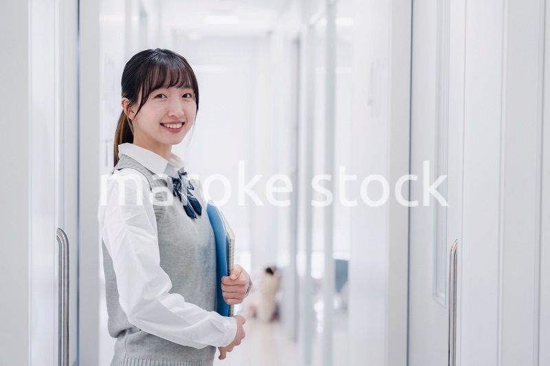 教材を持って校内を歩く女子高生