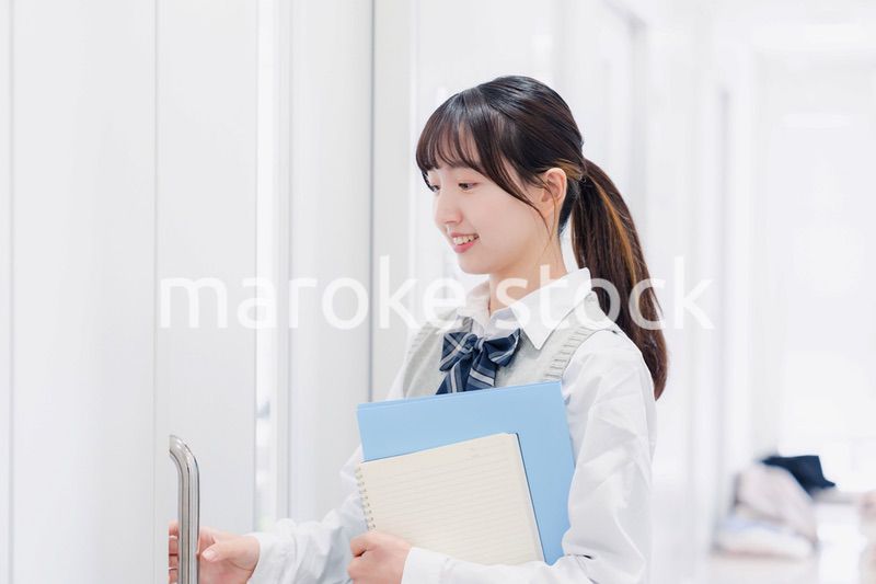 教材を持って校内を歩く女子高生