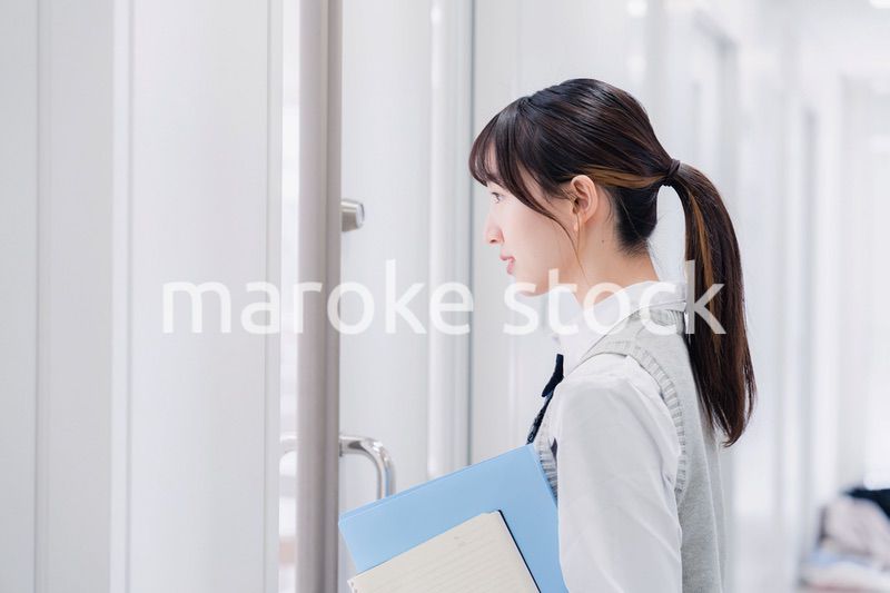 教材を持って校内を歩く女子高生